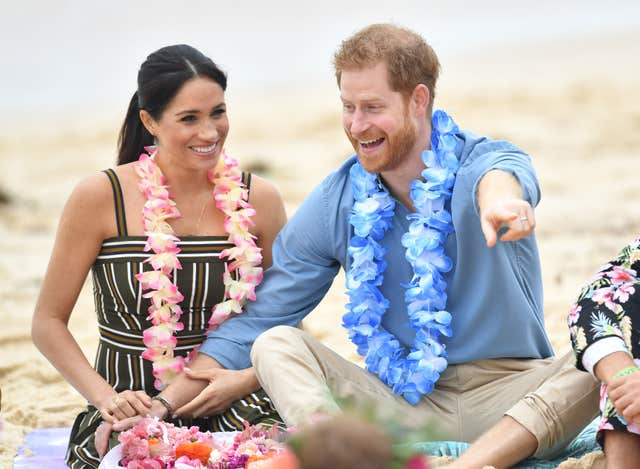 The Duke and Duchess of Sussex held hands as they joined the circle