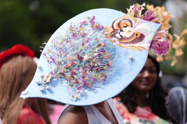 A woman wears a hat with a lion design