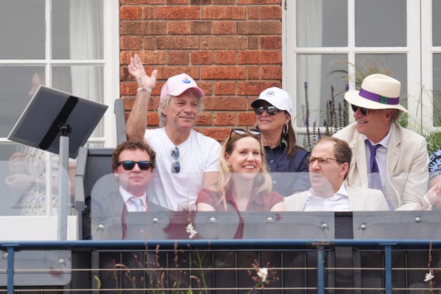 Jon Bon Jovi (top, left) waves to the crowd from the stands