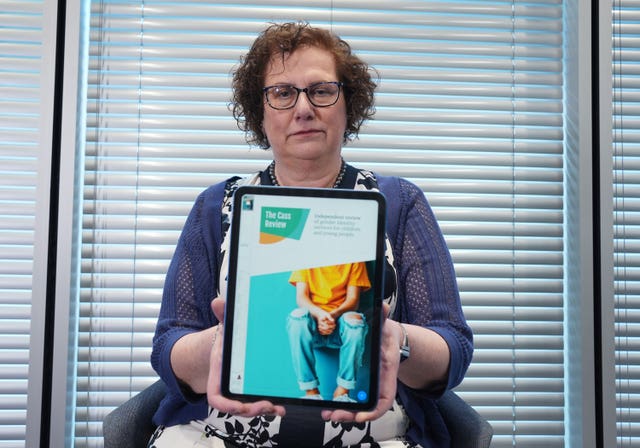 Dr Hilary Cass holding iPad showing cover of the Independent Review of Gender Identity Services for Children and Young People (The Cass Review)