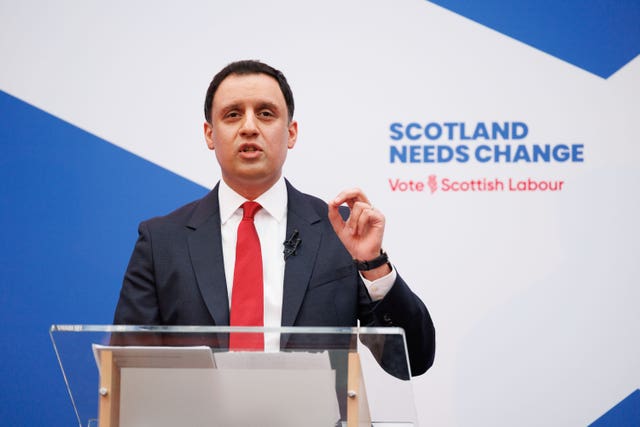 Anas Sarwar speaking from a lectern in front of Scottish Labour signage