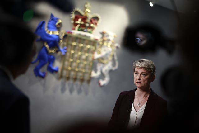 Yvette Cooper gives an interview to broadcasters in front of the National Crime Agency's crest.