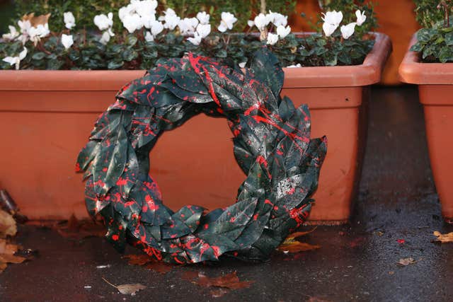 A laurel wreath left next to the sculpture