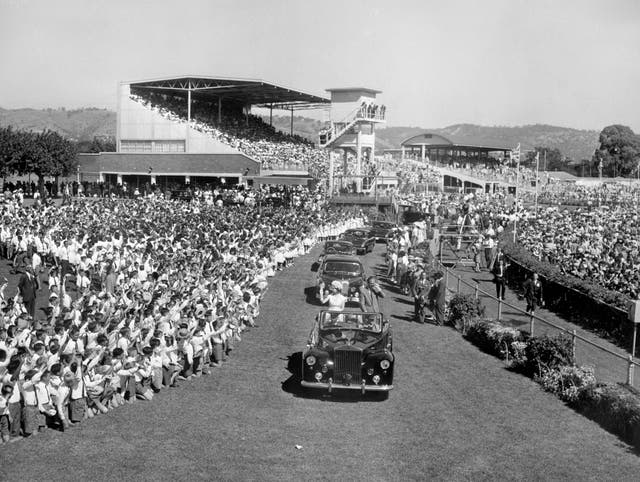 Queen Elizabeth II and the Duke of Edinburgh stand in an open Rolls Royce at Victoria Park racecourse in Adelaide, as 75,000 schoolchildren gave a rousing welcome in 1963