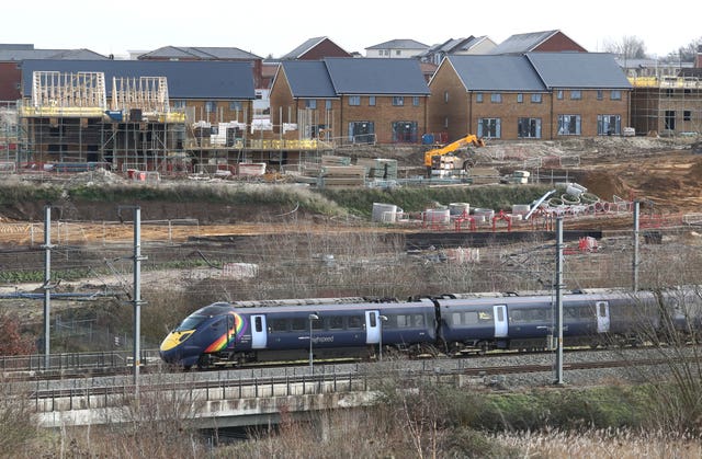 A Southeastern Highspeed train passes new houses being constructed on the Springhead development in Ebbsfleet, Kent