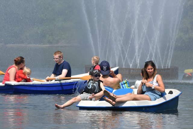 People enjoy the hot weather on the boating lake at Victoria Park, east London (John Stillwell/PA)