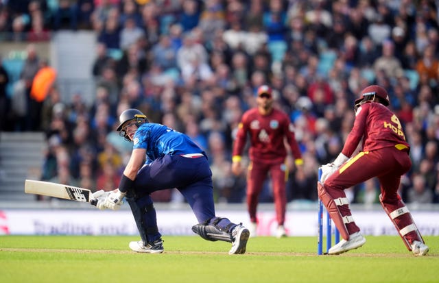 Jamie Smith sweeps the ball as the West Indies wicketkeeper looks on