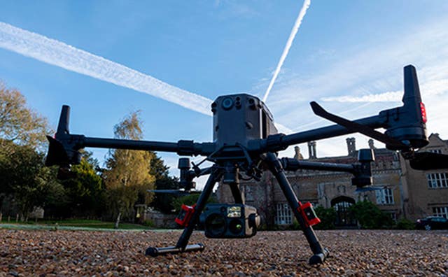 A wildlife drone with a camera underneath sits on a driveway 