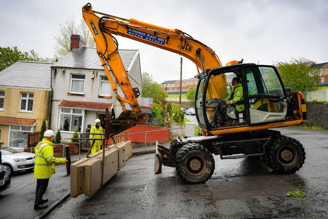 Council contractors place heavy concrete barriers at the top of Waun Wen Road, Swansea