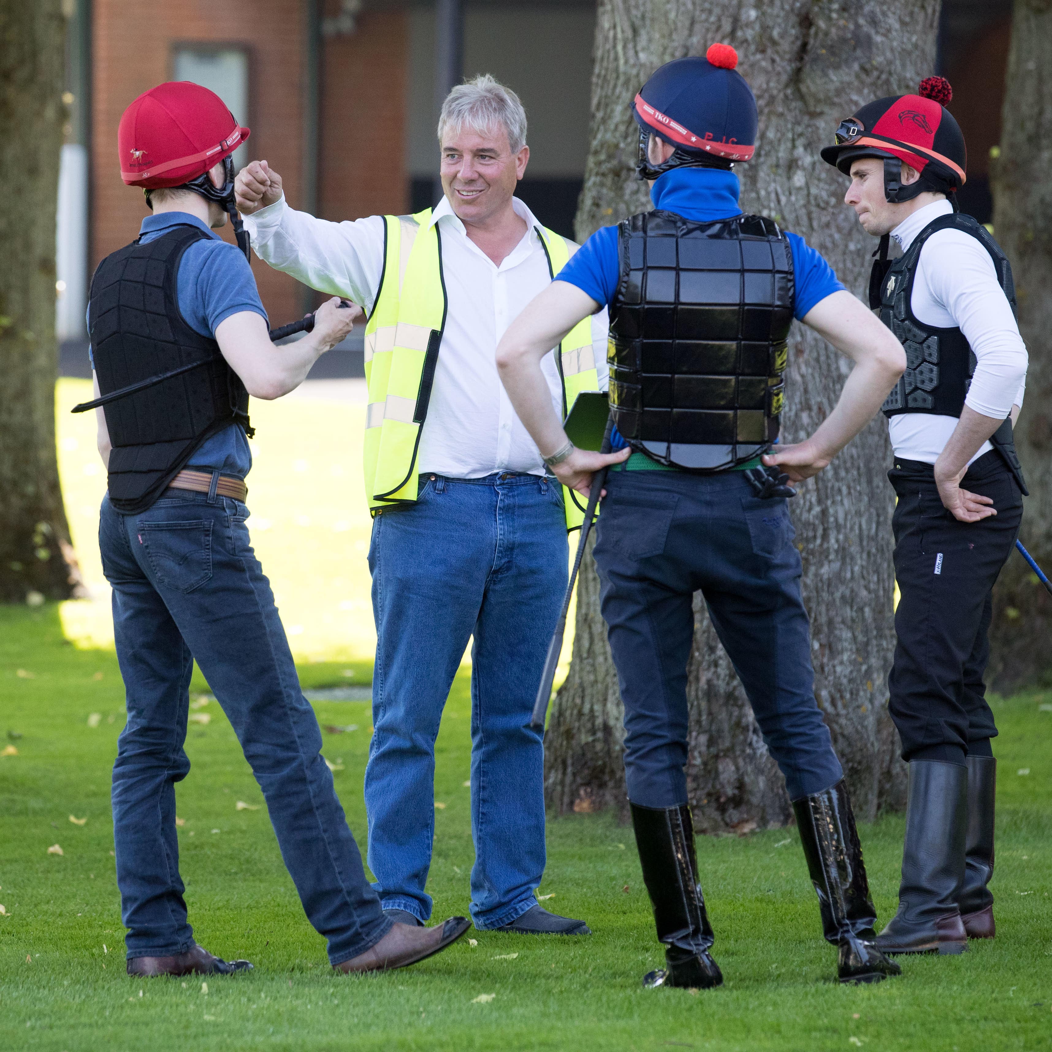 Trainer Wesley Ward (second left) talks to his jockeys at Ascot Racecourse