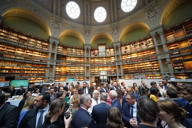 Queen Camilla (centre in white) speaks with guests during a visit to the Bibliotheque Nationale de France in Paris