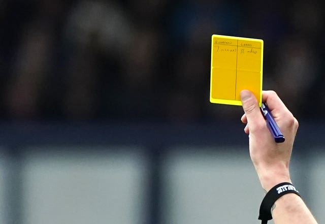 A referee holds up a yellow card