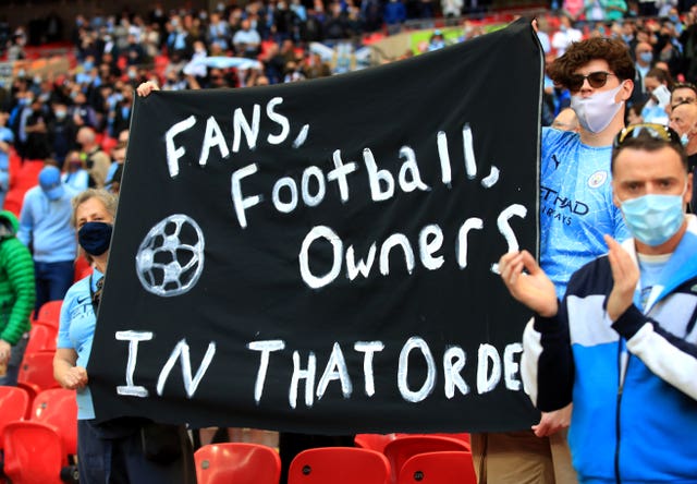 Manchester City fans hold up a banner protesting against the European Super League