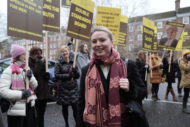 Charlotte Proudman walking past supporters with placards