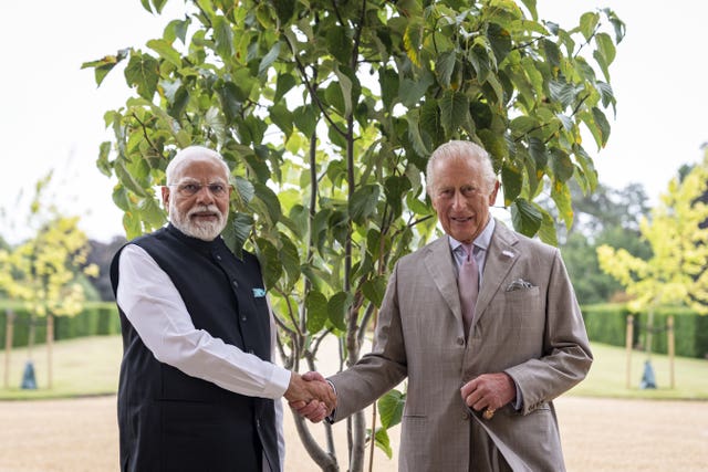 Mr Modi and the King shake hands before a tree at Sandringham
