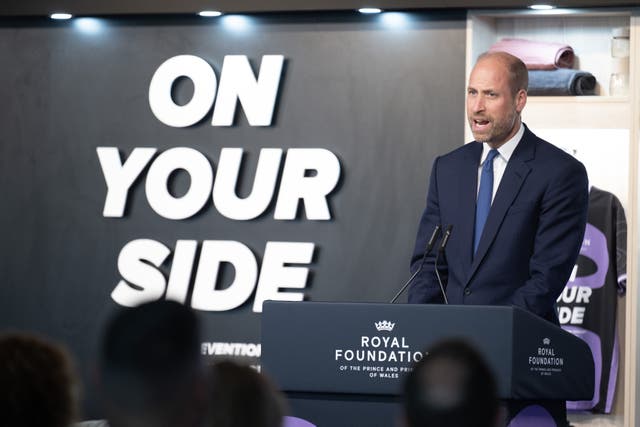 Prince of Wales speaking alongside a sign which reads 'On Your Side'