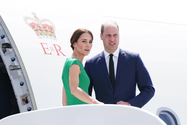 The then-Duke and Duchess of Cambridge stand on the steps of the plane as they depart Norman Manley International Airport in Jamaica