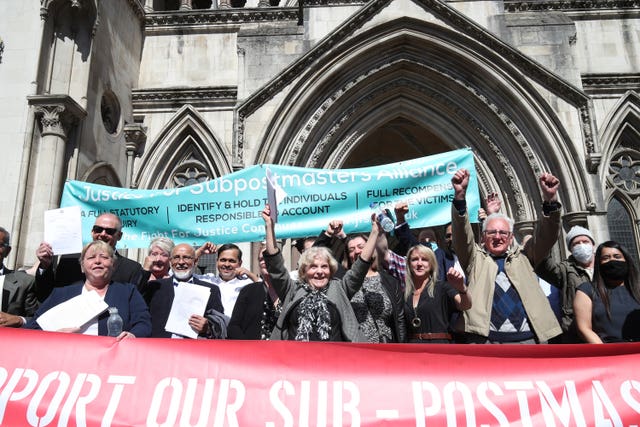 Former post office workers celebrate outside the Royal Courts of Justice, London (Yui Mok/PA)