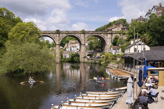 People enjoy the hot weather in rowing boats underneath the Knaresborough Viaduct on River Nidd in North Yorkshire