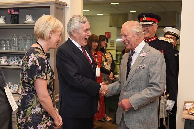 The King shakes hands with Gordon Brown as other dignitaries look on 