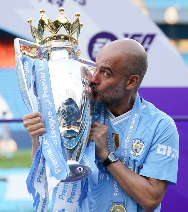 Manchester City manager Pep Guardiola kisses the Premier League trophy 