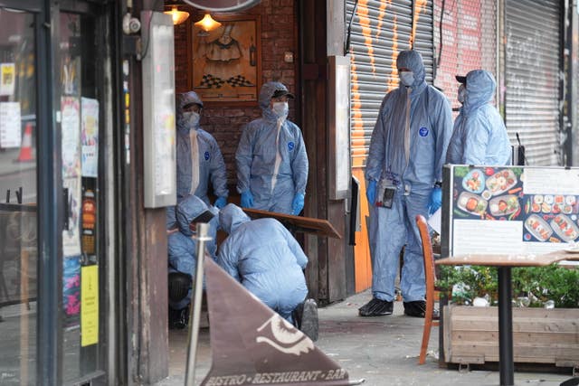 Police forensic officers at the scene of a shooting at Kingsland High Street, Hackney, east London