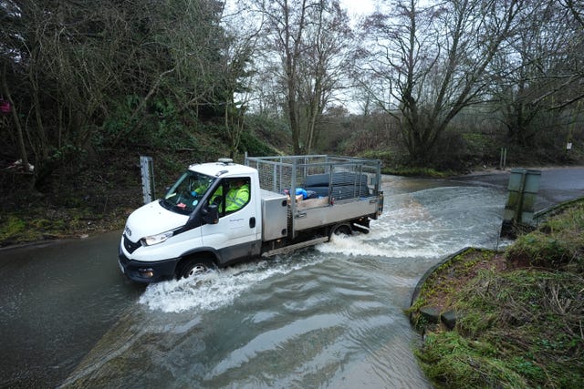 A flatbed truck ploughs through deep water