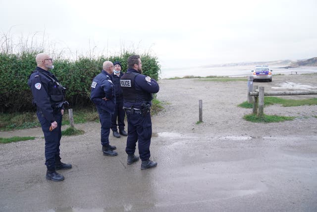 French police look out over the coast at Wimereux, north of Boulogne 