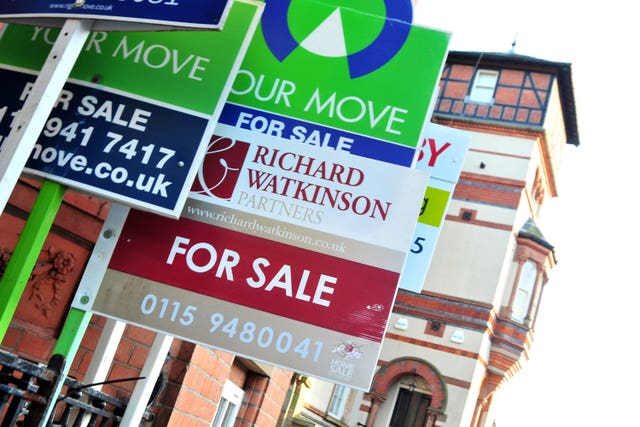 A number of 'for sale' signs outside houses