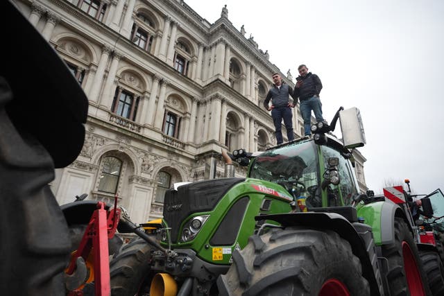 Farmers standing on a tractor