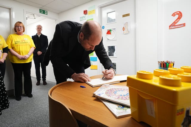 Prince of Wales signing a visitors' book