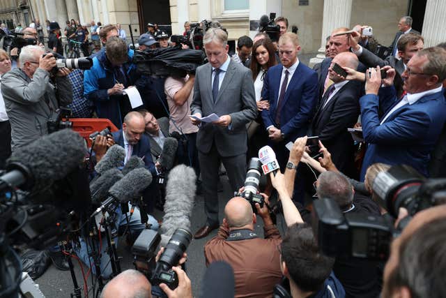 Ben Stokes stands by, centre right, as his lawyer Paul Lunt reads out a statement on his behalf outside Bristol Crown Court