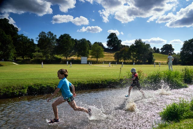 Children play in the River Tillingbourne on the weekend recreational cricket was allowed to resume. The waterway forms a natural boundary at Abinger Cricket Club in Surrey. Worplesdon and Burpham were the visitors on a sunny day in July