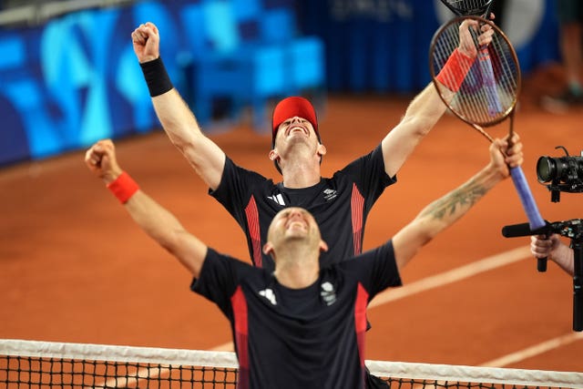 Andy Murray and Dan Evans, with their arms in the air and heads lofted, celebrate victory in Paris