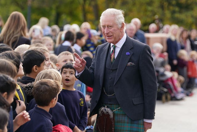 The King in a tartan kilt chats to school children in Glasgow in 2022