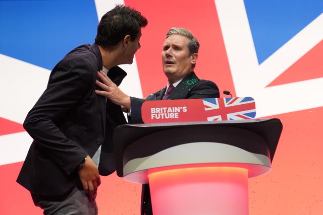 A protester throws glitter over Sir Keir Starmer during his keynote speech at the Labour Party Conference 