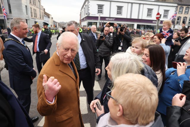 The King among a crowd of well-wishers on a street