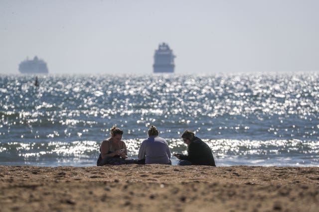 People sit on Bournemouth beach