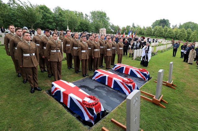 The coffins of two young privates and an unknown soldier, who fought during the first World War, during a burial service at Hermies Hill British Cemetery, near Albert, France