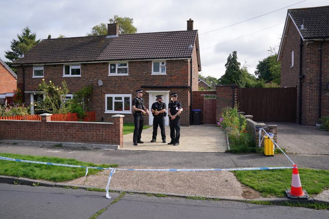 Surrey Police officers outside the property on Hammond Road in Woking, Surrey.