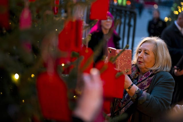 Attendees look at messages on the Kindness Tree