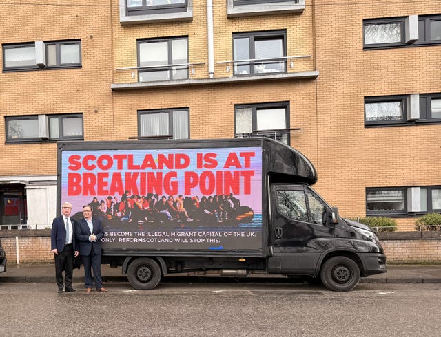 Reform UK candidates stand beside a campaign van