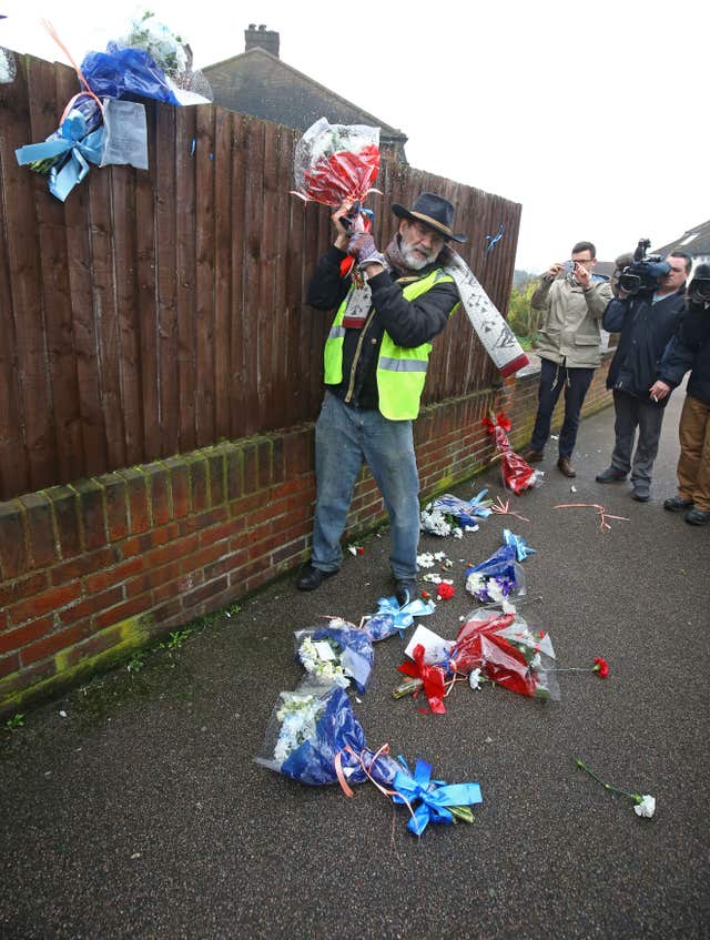 Mr Gordon pulls the flowers down from a fence (Gareth Fuller/PA)