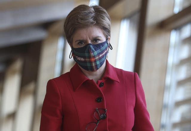 Nicola Sturgeon wearing a mask walking into the Holyrood chamber