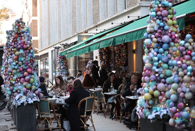 People dining on outdoor tables at a restaurant in Soho, London 