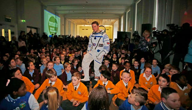 A man in a space suit with children at Liverpools World Museum 