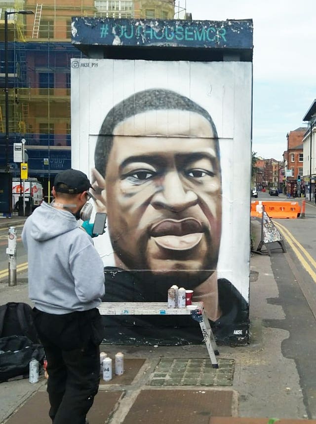 Street artist Akse P19 restoring the George Floyd memorial mural in Stevenson Square, Manchester (Manchester City Council/PA)