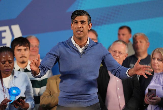 Prime Minister Rishi Sunak with his arms spread as he talks in front of an audience