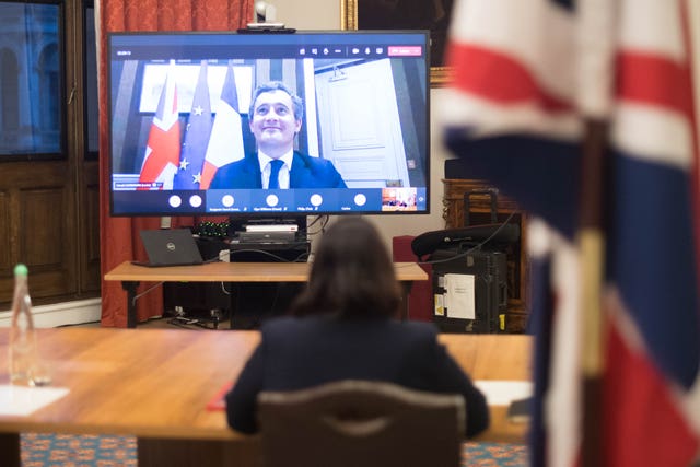 Home Secretary Priti Patel at the Home Office in central London, where she signed a new agreement with her French counterpart Gerald Darmanin (on screen) aimed at curbing the number of migrants crossing the English Channel in small boats in 2020