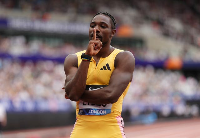 American world 100m and 200m champion Noah Lyles, wearing an all-yellow kit, poses on a track making a 